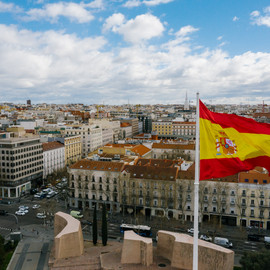 Stadt von oben mit spanischer Flagge im Vordergrund