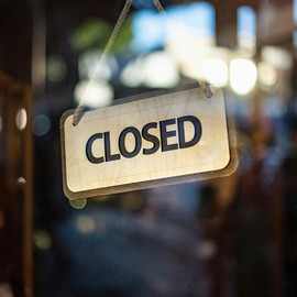 Schild mit Aufschrift "closed" an einer Glasscheibe